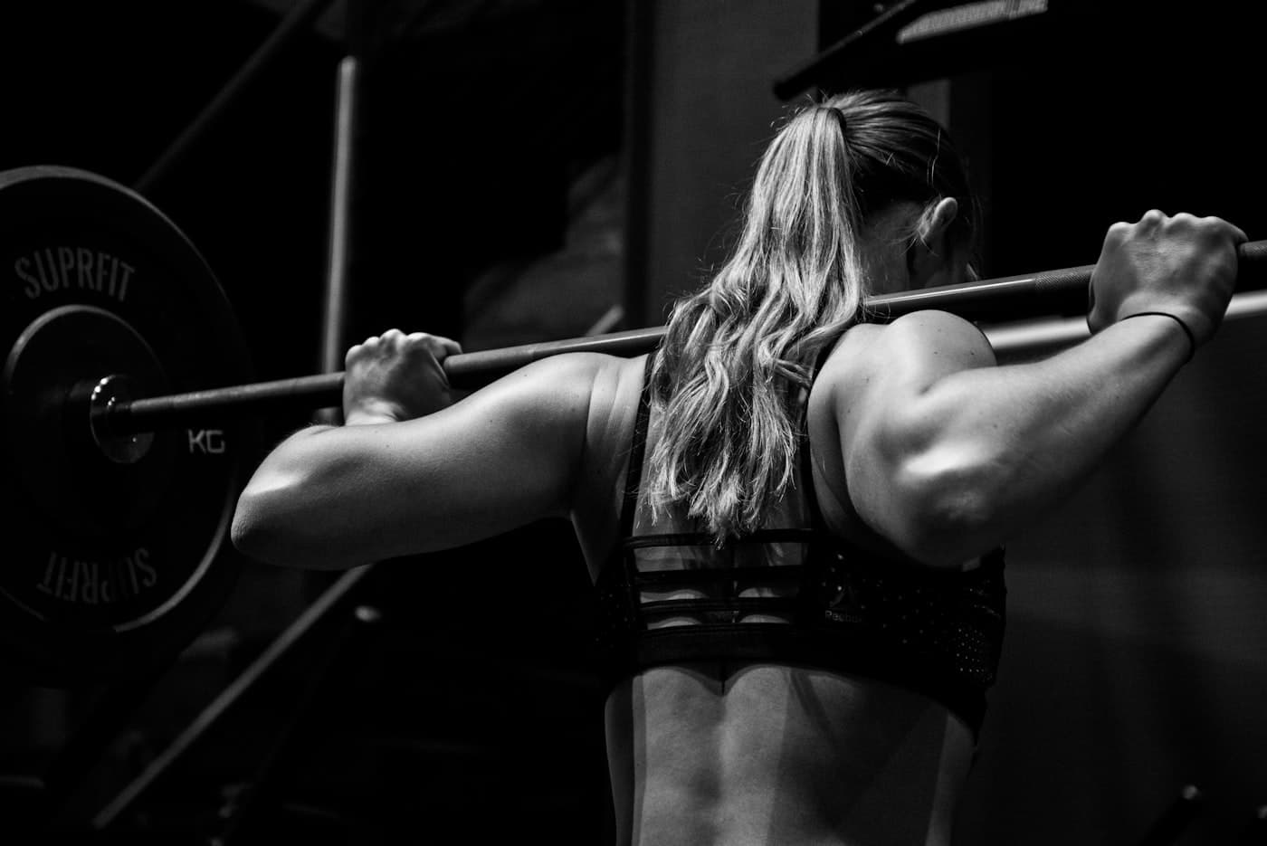 Person preparing to lift in a squat rack